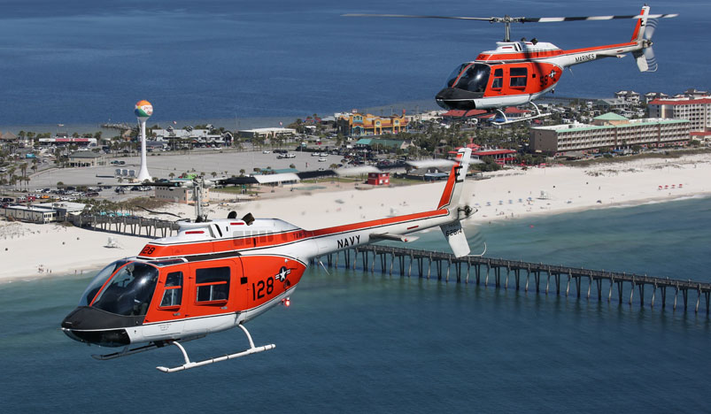 Two TH-57 Sea Ranger helicopters fly over the Emerald Coast in Pensacola, FL.